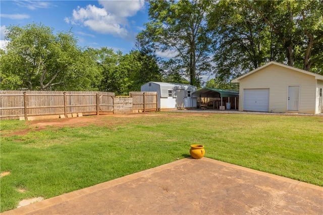 view of yard featuring a detached carport, an outdoor structure, and a garage