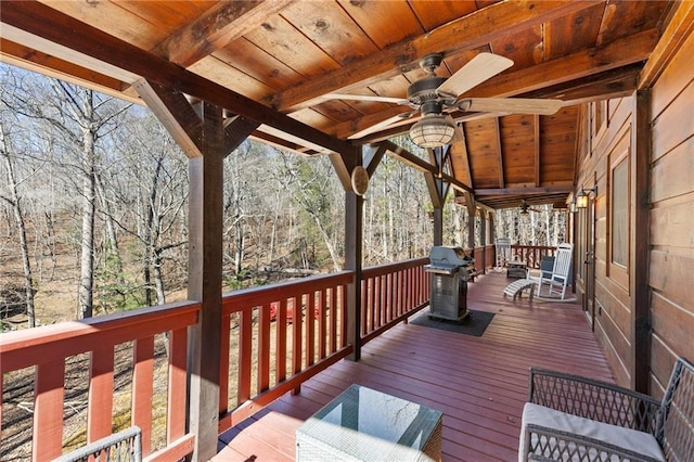 wooden deck with ceiling fan and area for grilling