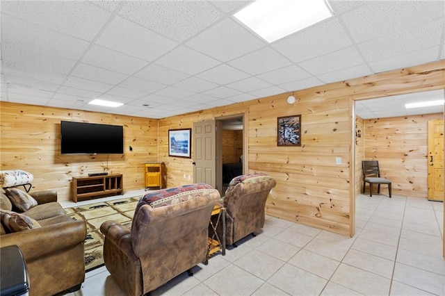 tiled living room featuring a paneled ceiling and wooden walls