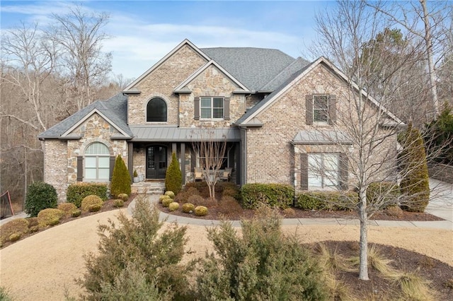 craftsman house with stone siding, a porch, and brick siding