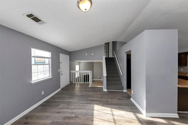 unfurnished living room with dark wood-type flooring and lofted ceiling