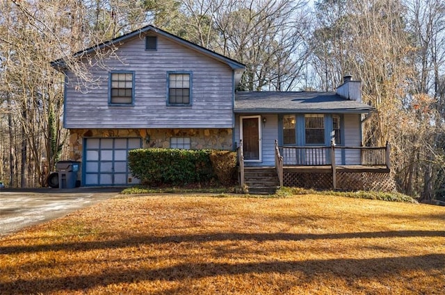 split level home featuring a garage and a front lawn