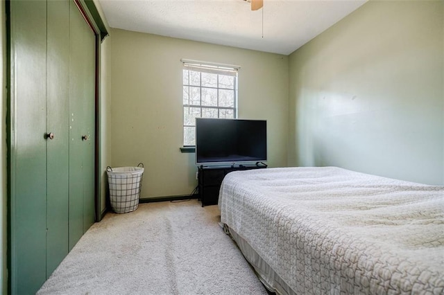 bedroom featuring light carpet, a closet, and ceiling fan