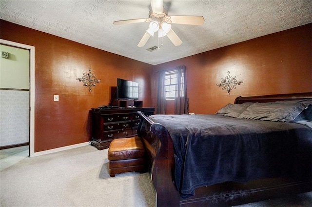 carpeted bedroom with ceiling fan and a textured ceiling