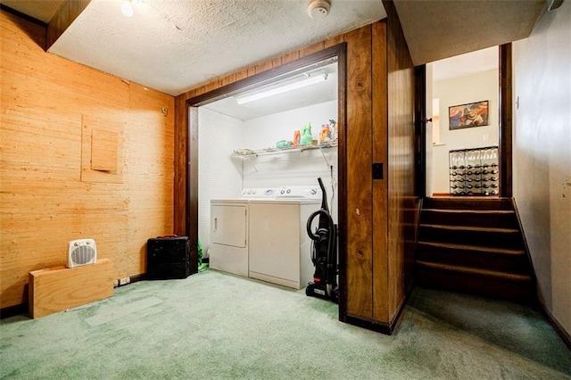 laundry area with independent washer and dryer, carpet floors, a textured ceiling, and wood walls