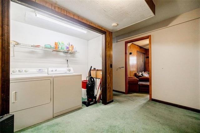 laundry room featuring washing machine and clothes dryer, light carpet, and a textured ceiling