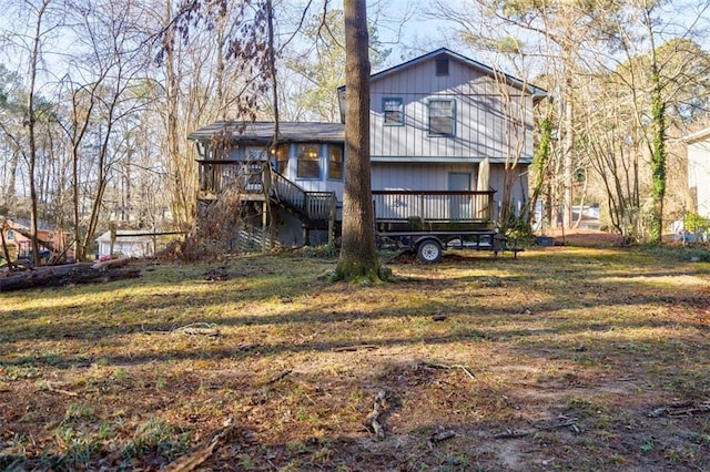 back of property with a wooden deck and a yard