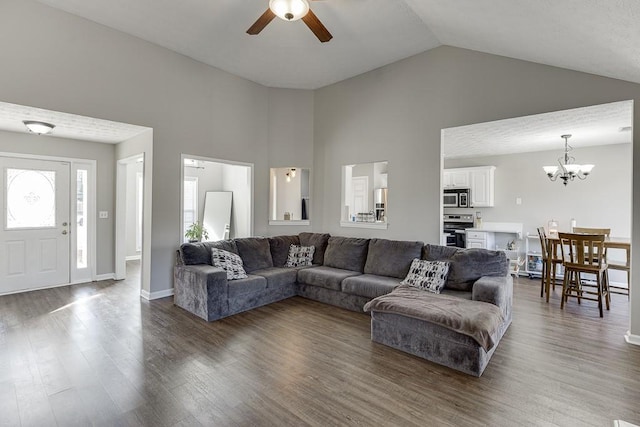 living room with dark hardwood / wood-style flooring, ceiling fan with notable chandelier, and vaulted ceiling