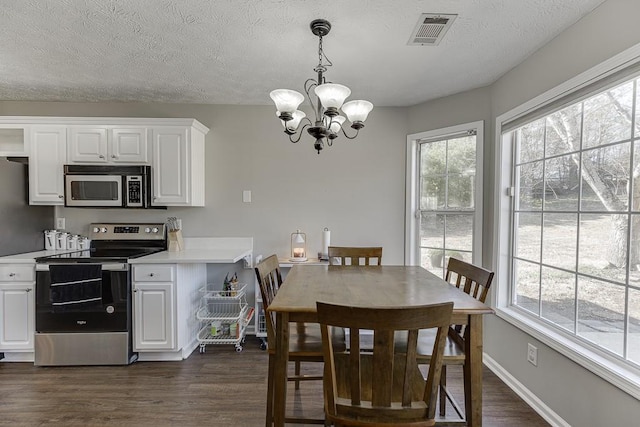 dining space with a chandelier, a textured ceiling, and dark hardwood / wood-style floors