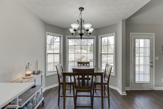 dining space featuring a textured ceiling, an inviting chandelier, and dark wood-type flooring