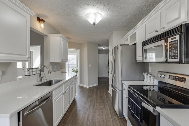 kitchen featuring stainless steel appliances, white cabinetry, dark hardwood / wood-style floors, and sink