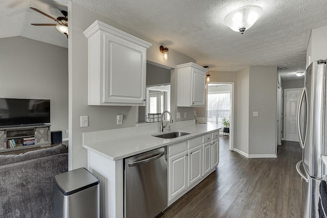 kitchen with lofted ceiling, sink, dark hardwood / wood-style floors, appliances with stainless steel finishes, and white cabinetry