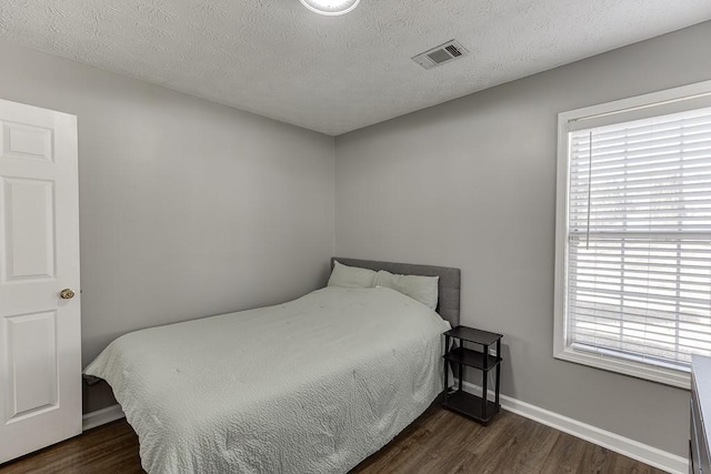 bedroom featuring a textured ceiling and dark wood-type flooring