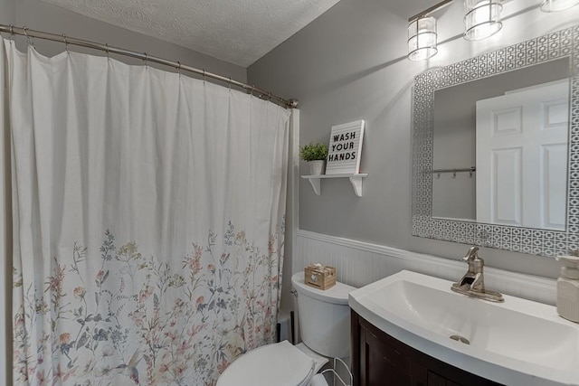 bathroom featuring vanity, toilet, and a textured ceiling