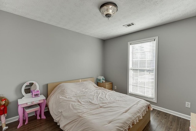 bedroom featuring dark hardwood / wood-style flooring and a textured ceiling