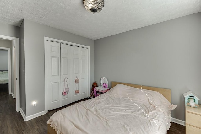 bedroom featuring a textured ceiling, dark hardwood / wood-style floors, and a closet