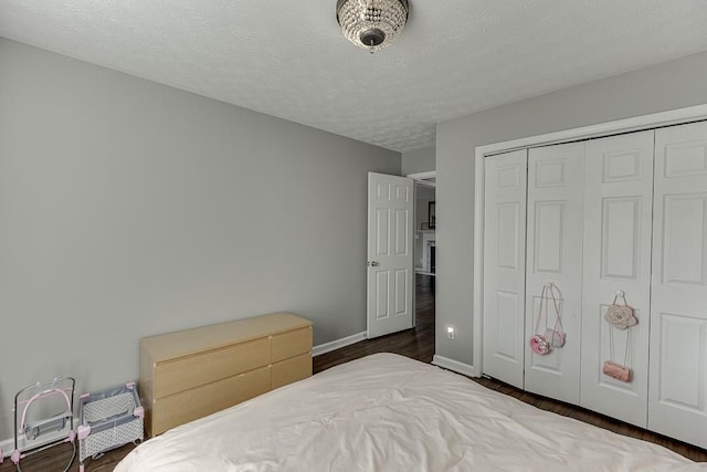 bedroom featuring a textured ceiling, dark hardwood / wood-style flooring, and a closet