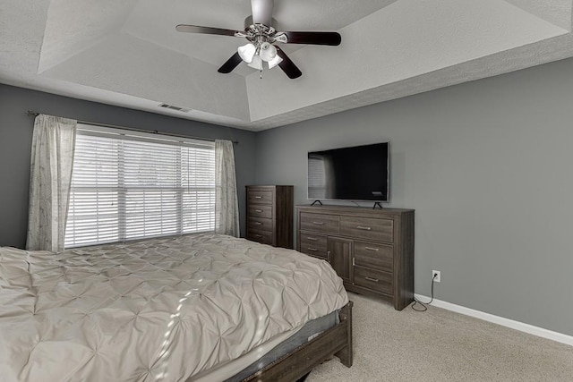 bedroom featuring a tray ceiling, ceiling fan, and light colored carpet