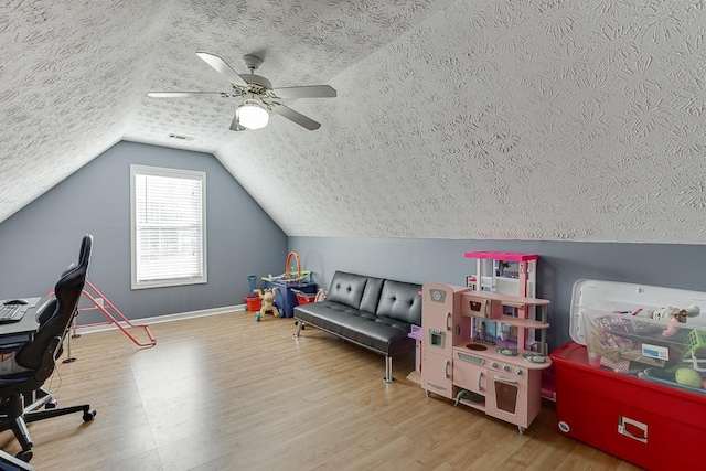 game room with a textured ceiling, ceiling fan, wood-type flooring, and lofted ceiling