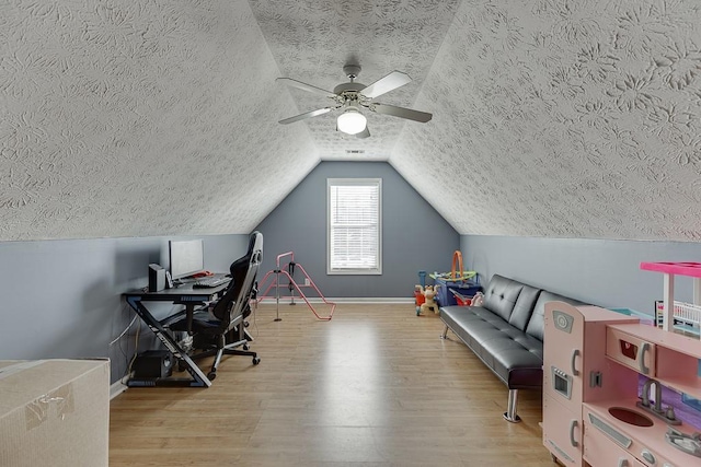 office with a textured ceiling, light hardwood / wood-style flooring, vaulted ceiling, and ceiling fan