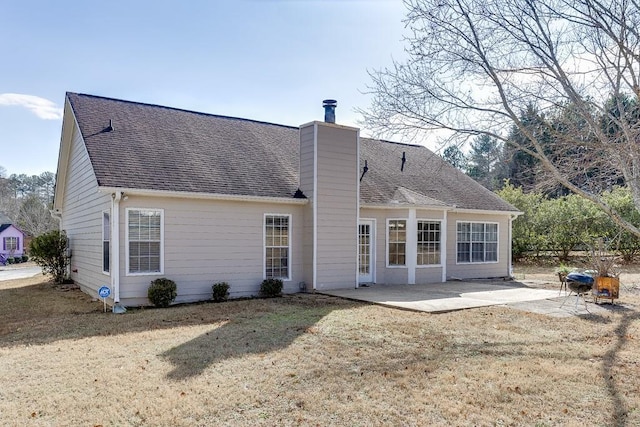 rear view of property featuring a lawn and a patio