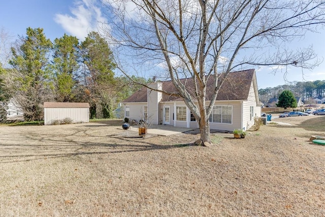 view of front of home with a shed and a patio area