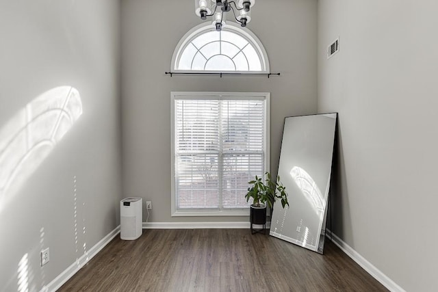 unfurnished room with dark hardwood / wood-style floors and a high ceiling