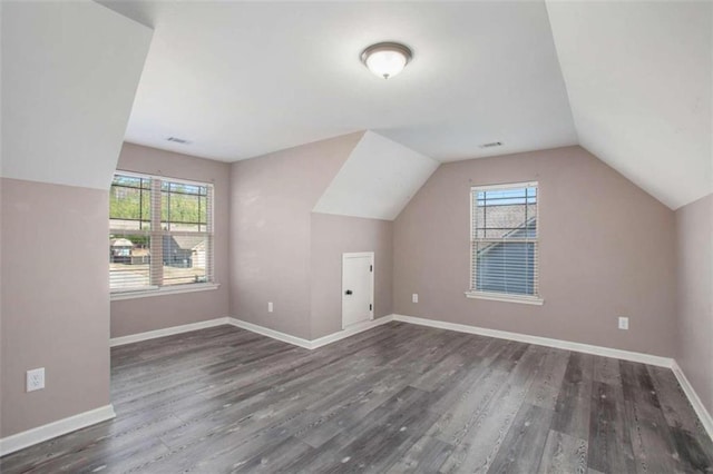 bonus room featuring lofted ceiling, dark hardwood / wood-style floors, and a wealth of natural light