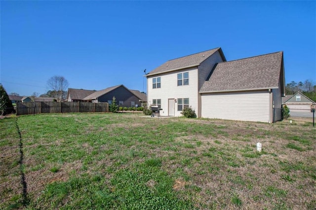 rear view of house featuring a lawn and a garage