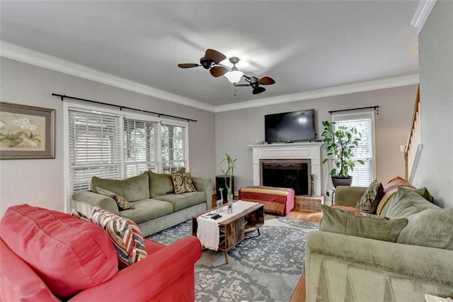 living room with crown molding, a brick fireplace, ceiling fan, and a wealth of natural light