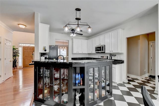 kitchen featuring ceiling fan with notable chandelier, decorative light fixtures, stainless steel appliances, dark hardwood / wood-style flooring, and sink