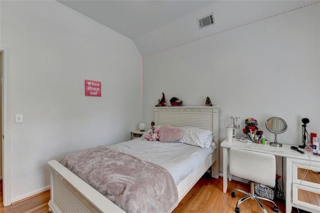 bedroom featuring lofted ceiling and light hardwood / wood-style flooring