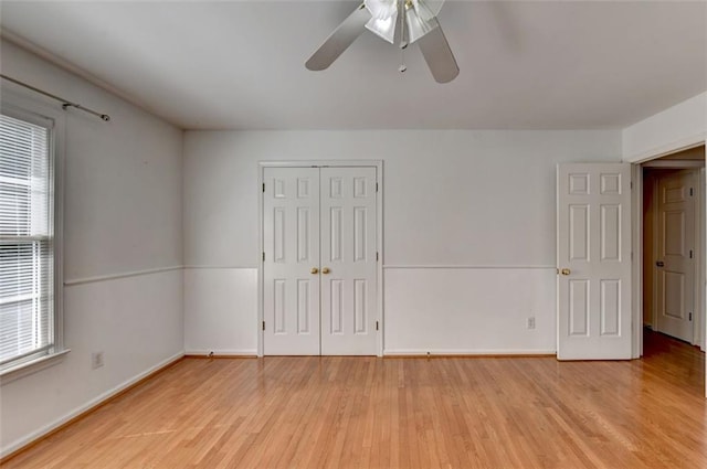 empty room with a wealth of natural light, ceiling fan, and light hardwood / wood-style floors