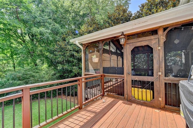 wooden terrace with a lawn and a sunroom