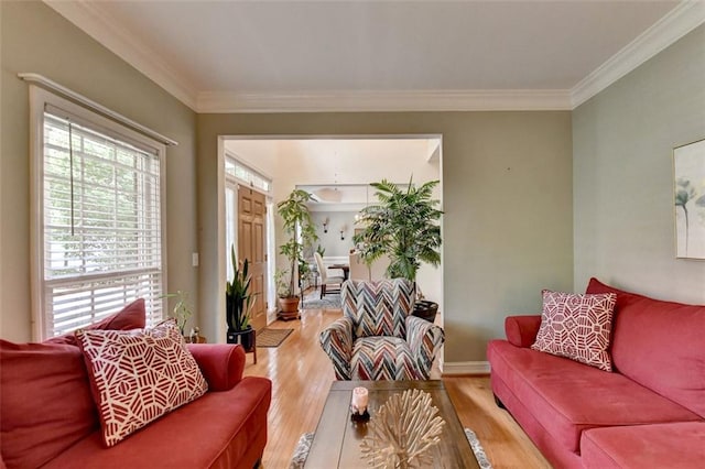 living room featuring a healthy amount of sunlight, ornamental molding, and wood-type flooring