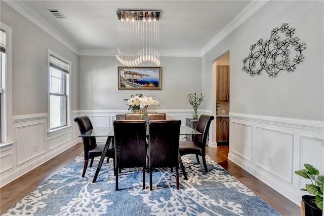 dining room with visible vents, crown molding, dark wood-style floors, and a notable chandelier