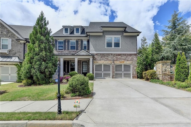 craftsman-style home featuring brick siding, a front lawn, driveway, and a garage