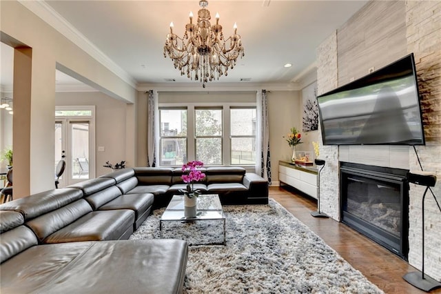 living area featuring recessed lighting, wood finished floors, ornamental molding, a large fireplace, and a notable chandelier