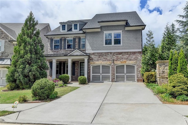 craftsman inspired home featuring concrete driveway, an attached garage, and brick siding