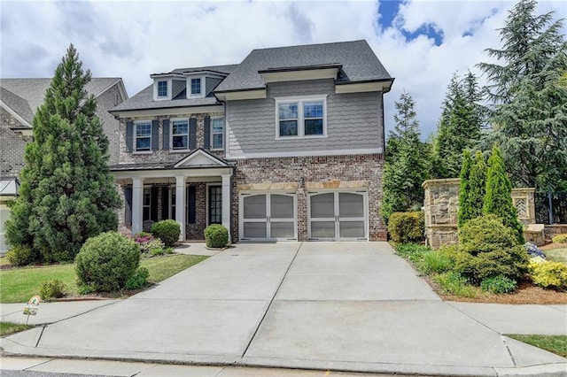 craftsman inspired home featuring brick siding, a garage, and concrete driveway