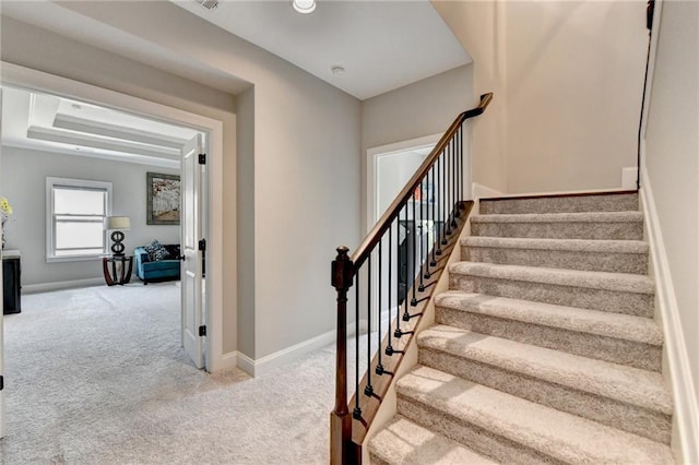 staircase featuring baseboards and carpet flooring