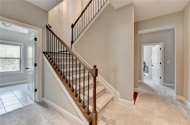 staircase featuring carpet floors and baseboards