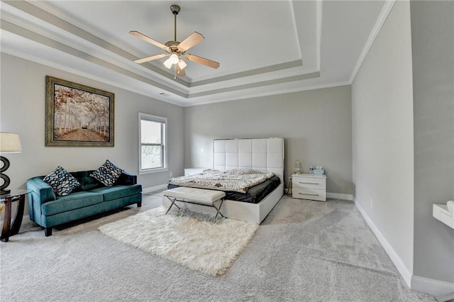 bedroom featuring a tray ceiling, a ceiling fan, light carpet, crown molding, and baseboards