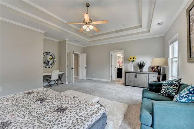 bedroom with a tray ceiling, visible vents, light carpet, crown molding, and baseboards