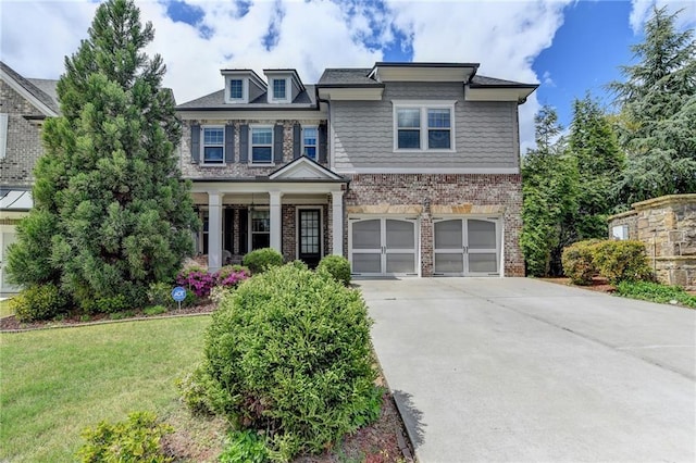 craftsman-style house with concrete driveway, brick siding, a front yard, and a garage