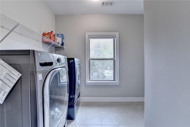 clothes washing area with tile patterned flooring, laundry area, visible vents, baseboards, and washer and dryer