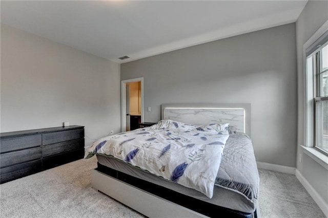 carpeted bedroom featuring visible vents, baseboards, and multiple windows