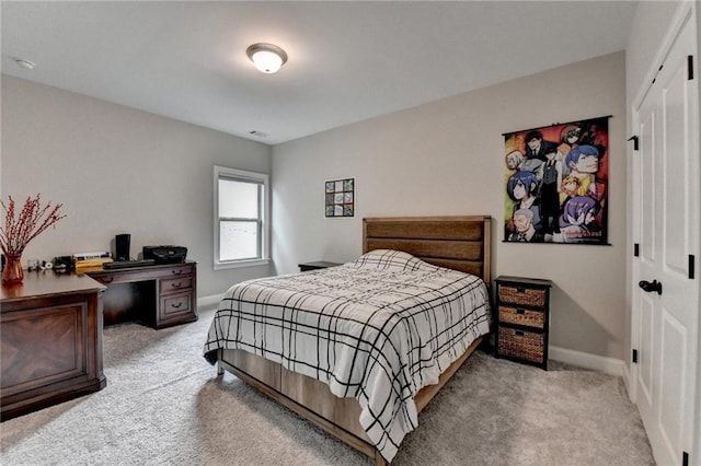 bedroom featuring a closet, baseboards, and light carpet