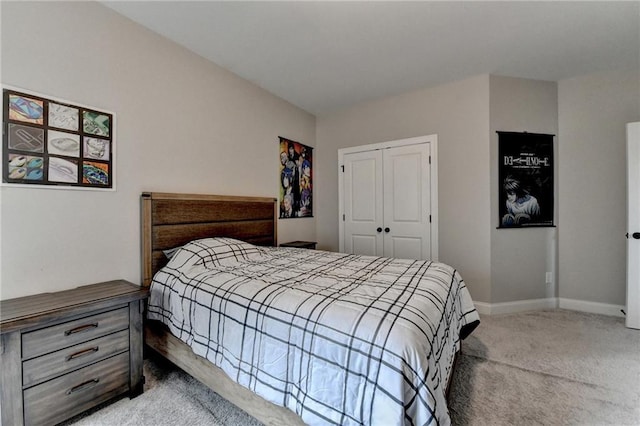 carpeted bedroom with a closet and baseboards