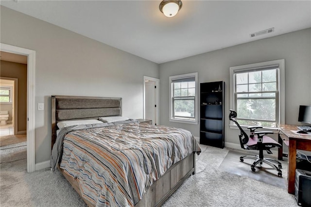 bedroom with light carpet, multiple windows, and baseboards